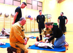 Uczniowie w asyście strażaków uczestniczą w pokazowej akcji udzielania pierwszej pomocy 