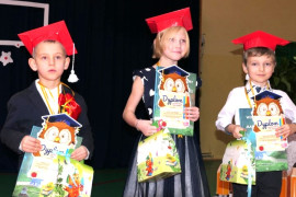 Dwie dziewczynki i chłopiec z dyplomami w ręku 