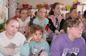 Grupa dzieci siedząca obok siebie 