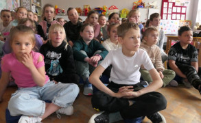 Grupa dzieci siedzi obok siebie