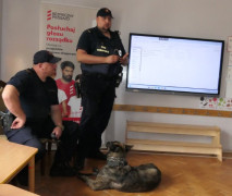Dwaj mężczyźni w mundurach. Obok leży pies 