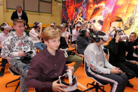Młodzież szkolna - uczniowie siedzą na krzesłach, w ręku trzymają okulary VR