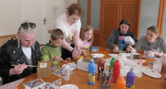 Osoby uczestniczą w warsztatach decoupage 