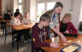 Osoby siedzą przy stolikach i grają w gry planszowe 