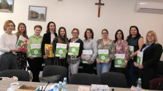Grupa kobiet na wspólnym zdjęciu. Uczestniczki szkolenia. Każda z Pań trzyma w ręku Apteczkę Pierwszej Pomocy Emocjonalnej 