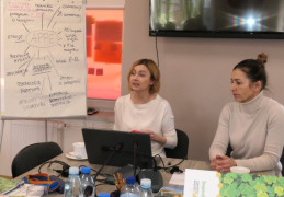 Dwie kobiety siedzą obok siebie przy stole. Kobiety prowadzą szkolenie 