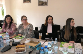 Cztery kobiety siedzą przy stole. Kobiety uczestniczą w szkoleniu 