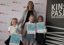 Trzy dziewczynki i kobieta. Dziewczynki trzymają w dłoniach dyplomy