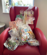 Czerwony fotel. Na fotelu znajdują się prezenty dla dzieci 