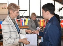 Kobieta wręcza chłopcu dyplom 