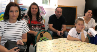 Dorośli i dziecko siedzą obok siebie