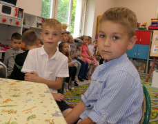 Dwaj chłopcy siedzą w ławce 