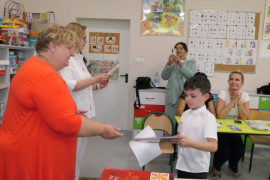 Kobieta wręcza nagrodę chłopcu 