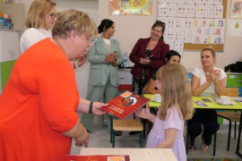 Kobieta wręcza dziewczynce nagrodę książkową 