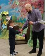 Mężczyzna wręcza małemu chłopcu dyplom 