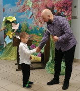 Mężczyzna wręcza małemu chłopcu dyplom 