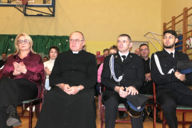 Osoby siedzą obok siebie na krzesłach
