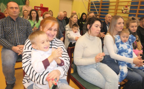Grupa osób siedząca obok siebie na krzesłach