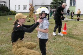 Mały chłopiec przymierza strażacki kask 