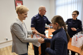 Dziewczynka odbiera prezent od kobiety 