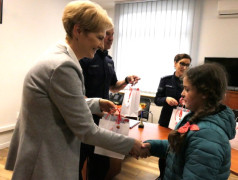 Dziewczynka odbiera prezent od kobiety 