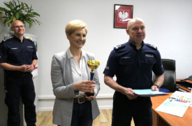 Kobieta i dwaj mężczyźni. Kobieta trzyma w ręku puchar