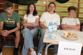 Dwie dziewczyny i dwaj chłopcy siedzą obok siebie