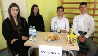 Dwie dziewczyny i dwaj chłopcy siedzą przy stoliku 