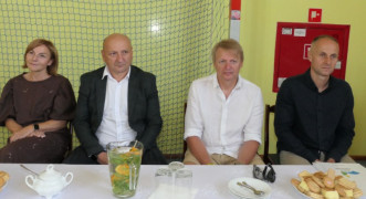 Kobieta i trzej mężczyźni siedzą obok siebie