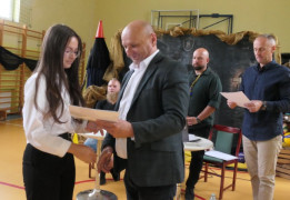 Mężczyzna wręcza dziewczynie dyplom 