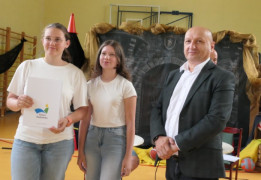 Dwie dziewczyny i mężczyzna. Jedna z dziewczyn trzyma w ręku dyplom 