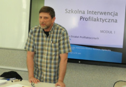 Mężczyzna stoi przy biurku. Mężczyzna prowadzi szkolenie dla nauczycieli 