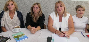 Cztery kobiety siedzą obok siebie. Kobiety uczestniczą w szkoleniu. 