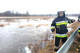 Strażak OSP Szczepocice podczas monitorowania poziomu wody na rzece Warcie 