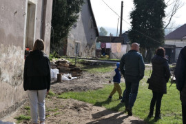 Grupa osób przed zalanym budynkiem 