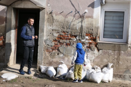 Mężczyzna, dzieci, worki  paskiem, budynek, który został zalany przez wodę 