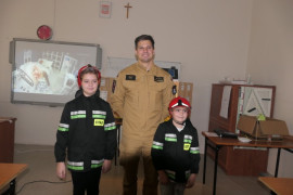 Uczennice PSP w Strzałkowie w towarzystwie strażaka PSP w Radomsku. Dziewczynki ubrane są w stroje strażaka 