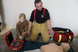 Strażak i dziewczynka podczas akcji pokazowej - pierwsza przedmedyczna pomoc